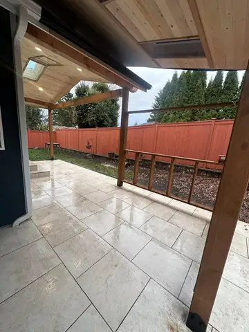 Covered patio with tiled floor and wood posts
